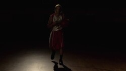 A basketball player performs dribbling tricks with two basketballs at center court of a gym. Stock Footage