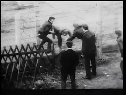 B/W 1961 men helping another man escape thru barbed wire fence of Berlin Wall / Germany / newsreel Stock Footage