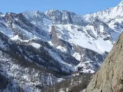 Pan up as young man scales cliff towards father above Stock Footage