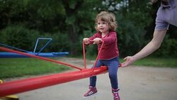 Father and girl riding on seesaw Stock Footage