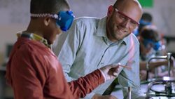 Teacher supervises a student using Bunsen burner Stock Footage