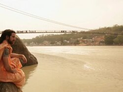 Sage sitting at ganges riverbank, Laxman Jhula, Rishikesh, Uttarakhand, India Stock Footage