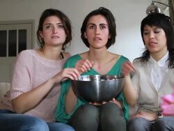 Girls on sofa watching Television and eating popcorn Stock Footage