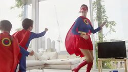 Superhero mother and children playing in living room Stock Footage