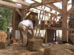 WS PAN Carpenter places bale of straw during framing of an energy efficient post / Grass Lake, Michigan, USA  Stock Footage
