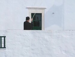 CU TU Shot of man ringing bell in monastery at wall of rock / Amorgos, Cyclades, Greece Stock Footage