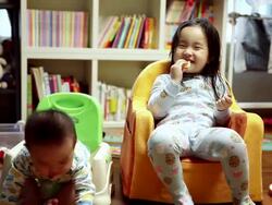 MS Shot of Korean brother and sister sitting on small chair / Jeju, Jeju-do, South Korea  Stock Footage