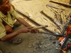 MS SLO MO Shot of small fire and people heating machete blades / Muang Ngoi, Luang Prabang, Laos Stock Footage