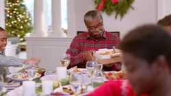Happy family pass plates around table for Christmas dinner (dolly-shot) Stock Footage