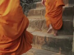 CU Buddhist monks climb up the ancient steps of a temple in Angkor Wat at sunrise / Siem Reap, Cambodia Stock Footage