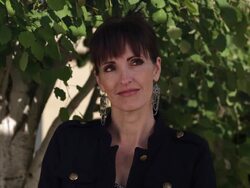 Woman with big earrings with small smile glancing up. Stock Footage