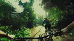 Point of view pedalling on mountainbike with girl Stock Footage