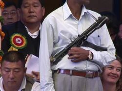 MS TU Guard holding gun at Buddhist ceremony AUDIO / Dharamsala, Himachal Pradesh, India Stock Footage