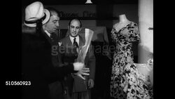 1947: MARTIN'S DEPARTMENT STORE EXEC. MEETING: INT WS Executives talking in closed department store. MS Two men looking at sale poster. MS Man in chair (implies President) looking at poster. MS Man looking at dress sale advertisement poster. NYC Instructional Video