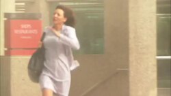 Crowds of people run down a city street and through a revolving door to escape a tornado in this reenactment. Stock Footage