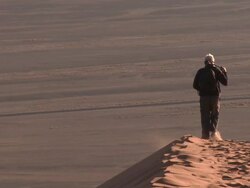 Man with tripod walking on sand dune, Sossusvlei, Namib-Naukluft, Namibia Stock Footage