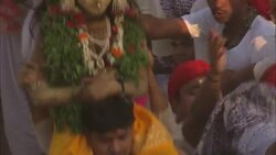 A man carries a woman wearing an elaborate costume on his back during the Diwali holiday. Stock Footage