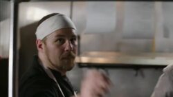 Restaurant chef pulls order ticket down and spikes it on check spindle in kitchen Stock Footage