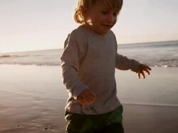 Child walking on beach Stock Footage
