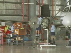 Engineers in hangar performing maintenance on Metroliner engine, Australia Stock Footage