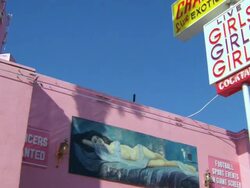 MS View of pink stucco building with picture of woman laying on bed and sign of Girls Girls Girls / Los Angeles, California, USA Stock Footage