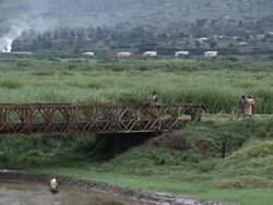 Exterior steady shot of a field with a bridge in view.  Stock Footage