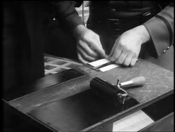 B/W 1930s close up hands of Amelia Earhart being fingerprinted by policeman / newsreel Stock Footage