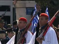 Crisis-hit government scales back parade, PM in Brussels News Clip