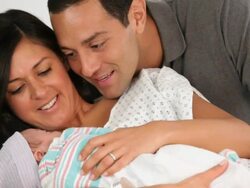 MS Mother and Father with Newborn Laying in Hospital Bed / Richmond, Virginia, USA Stock Footage