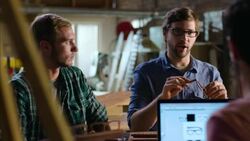 Wood shop owner teaches workers how to assemble glasses Stock Footage