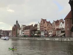 WS View of old town at river Motlawaand boat moving in river / Gdansk, Baltic Coast, Poland Stock Footage