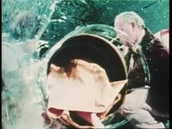 A young girl crawls through an inflatable tunnel and into a spacesuit to keep from being exposed to germs. News Clip