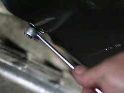 CU SLO MO  Mechanics tightening nut with wrench on oil pan  / Bergenfield, , New Jersey, USA   Stock Footage