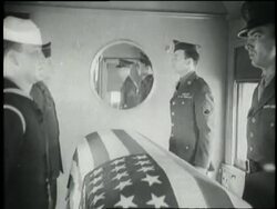 An honor guard stands near the flag-draped coffin of President Franklin D. Roosevelt as the funeral train leaves a train station. News Clip
