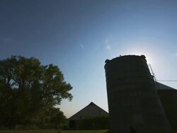 Timelapse of clouds over a farm silo barn Stock Footage