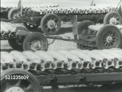 MOT 1939: LANGLEY FIELD, VIRGINIA: ARMY GENERAL HEADQUARTERS: GHQ M-DAY PREP: Long open cart w/ bombs lying side by side pulling into frame, more bomb carts parked BG. MS Two males in uniform arming bombs, turning nose tip w/ tool Instructional Video
