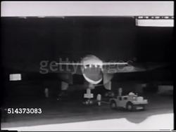 1964: EXPERIMENTAL AIRCRAFT: HA Angled WS 'North American Aviation' sign on aircraft warehouse hangar, VS People waiting outside, watching, VS XB-70 'Valkyrie' supersonic research aircraft being pulled out of building. Instructional Video