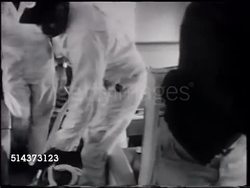 1966: UNITED AIRLINES JANITORIAL: WS (POV Moving vehicle) Passing in front of jet, cabin cleaners cleaning, vacuuming, wiping, leaving. DRAMATIZATION: MS 24-hour clock. UA Pilot Captain Lowell Hecock checking in w/ 'Bill', looking at flight folder. Instructional Video