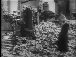 B/W 1940 woman watches two boys grab chair from bombed out building after London Blitz / educational Stock Footage