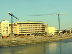 WS Building under construction, man fishing in foreground / Skopje, Macedonia Stock Footage