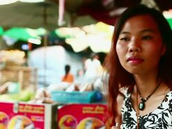 MS TU TD SLO MO Shot of woman sitting in market and drinking drink through straw / Luang Prabang, Laos Stock Footage