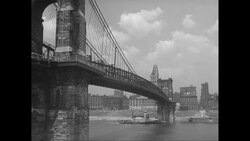 WS Tug boat moving on river under John A. Roebling Suspension Bridge, buildings of Cincinnati in background / Cincinnatii, Ohio, United States Stock Footage