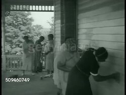 1938: ROOSEVELT ESTATE: President Franklin D. Roosevelt (1882-1945) sitting at desk. African American women cleaning under porch, wiping clapboards of house. Instructional Video
