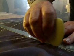 CU Shot of man measuring out fabric with ruler and clover chalk / South Africa Stock Footage