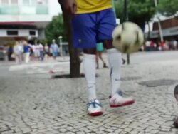 MS TS Shot of coloured guy with brazilian trikot playing freestyle football at a street corner / Rio de Janeiro, Brazil  Stock Footage