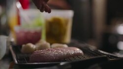 Chef sprinkles seasonings over fish fillet in restaurant kitchen Stock Footage