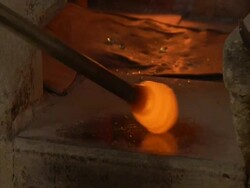 Glass blowing, ball of molten glass rotated on a pole, expanding as air is blown into it, Egypt, (sound available) Stock Footage