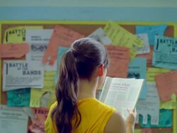 MS Young lady reading magazine and walking toward Stock Footage