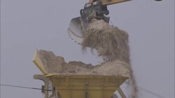 A loader dumps dirt into a hopper that drops it into a pile. Stock Footage