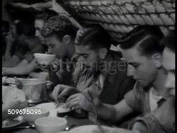 1942: ON WWII SHIP: US Officer talking on engine room telephone. VS Young adult male soldiers eating at table. DRAMATIZATION: Officers talking in wardroom about location of submarines, officer making call to 'control' asking for course change. Instructional Video